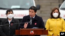 El presidente de Perú, Pedro Castillo, da un discurso, flanqueado por su esposa Lilia Paredes, (izq.) y la vicepresidenta Dina Boluarte durante una ceremonia en el palacio de gobierno para recibir ambulancias donadas por Japón, en Lima, Perú, el jueves 21 de julio de 2022.