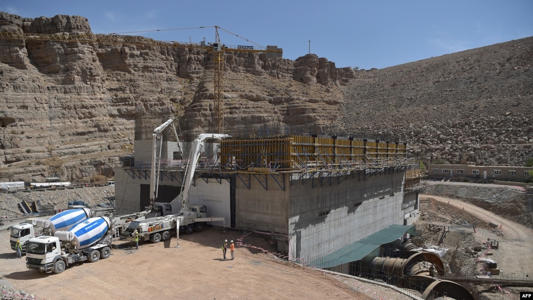 FILE - In this photograph taken on March 21, 2021, laborers work on the construction of a powerhouse at the hydroelectric Kajaki Dam in Kajaki, northeast of Helmand Province. The second phase of the dam's construction was completed by the Turkish company 77 Construction.