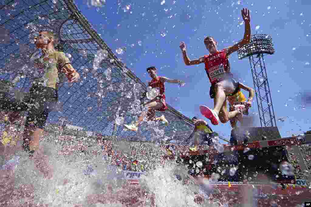 Michael Curti of Switzerland, right, competes in a Men's 3000 meters steeplechase heat during the athletics competition in the Olympic Stadium at the European Championships in Munich, Germany.