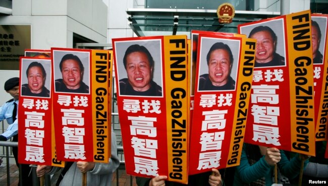 资料照：香港民众在中联办前手举多年失踪的中国著名维权律师高智晟的画像与标语。（2010年2月4日）