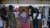 Seorang perempuan menandai surat suaranya di bilik suara sebuah tempat pemungutan suara di Kisumu, Kenya, 9 Agustus 2022. (Brian ONGORO / AFP)