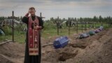 一位神职人员在基辅郊外的布查为在俄罗斯占领期间被俄军杀害的身份仍然不明的乌克兰平民祈祷。(2022年8月11日)