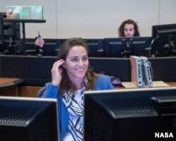 In this July 23, 2017 photo, NASA astronaut Nicole Aunapu Mann sits at the CAPCOM console in Houston's Mission Control Center.