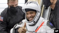 FILE - NASA astronaut Victor Glover is helped out of the SpaceX Crew Dragon Resilience spacecraft onboard the SpaceX GO Navigator recovery ship, May 2, 2021.