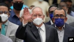 Mantan Perdana Menteri Malaysia Najib Razak (tengah), mengenakan masker, melambaikan tangan saat tiba di Pengadilan Banding di Putrajaya, Malaysia, Selasa, 23 Agustus 2022. (AP/Vincent Thian)