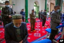 FILE - Uyghurs and other members of the faithful pray during services at the Id Kah Mosque in Kashgar in far west China's Xinjiang region, as seen during a government-organized visit for foreign journalists on April 19, 2021.