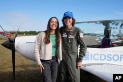 Seventeen year old Anglo-Belgian pilot, Mack Rutherford, right, poses with his sister Zara Rutherford after landing at the Buzet airfield in Pont-A-Celles, Belgium, Tuesday, Aug. 23, 2022. (AP Photo/Virginia Mayo)