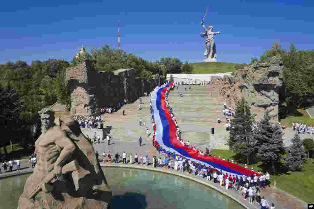 People carry a giant Russian flag during celebration of the Day of The National Flag in Mamayev Kurgan, the World War II Battle of Stalingrad memorial, in Volgograd, Russia. (AP Photo/Alexandr Kulikov)