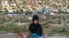 Sara, 14, duduk di kuburan dan membaca buku sambil menjual air di pemakaman di Kabul, 30 Juli 2022. (AP Photo/Ebrahim Noroozi)