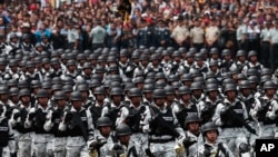 FILE - Members of Mexico's National Guard march in the Independence Day military parade, in the capital's main plaza, the Zocalo, in Mexico City, Sept. 16, 2019. 