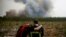 Firefighters react as they work to contain a fire in Saint-Magne, as wildfires continue to spread in the Gironde region of southwestern France, Aug. 11, 2022. 