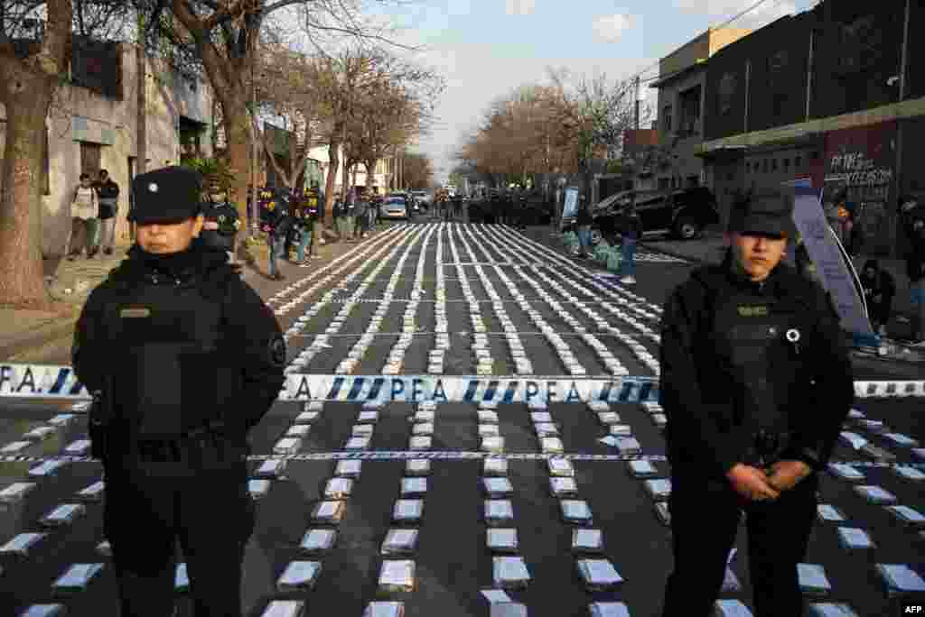 Police stand guard over seized packages of cocaine displayed to the press in Rosario, Santa Fe province, Argentina. Federal Police officers seized more than 1,600 kilos of cocaine, valued at some US$60 million, which were about to leave through the waterway to Dubai, authorities said.&nbsp;