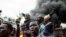 Supporters of Kenya's Azimio La Umoja Party (One Kenya Coalition Party) presidential candidate Raila Odinga react past burning tyres during a protest against the results of Kenya's general election in Kibera, Nairobi, western Kenya on August 15, 2022. 