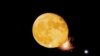 Petards explode in front of the waning moon during a fireworks display in Mqabba, Malta, Aug. 13, 2022. 