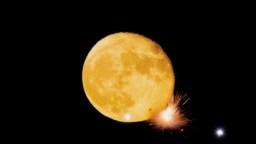 Petards explode in front of the waning moon during a fireworks display in Mqabba, Malta, Aug. 13, 2022. 