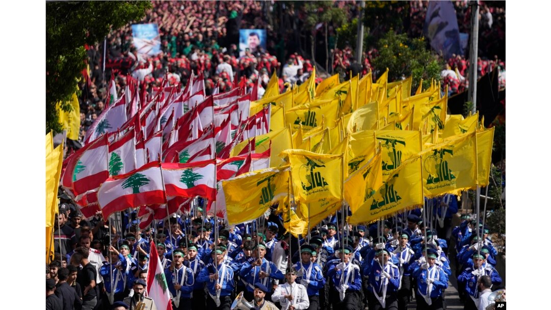 Pramuka Syiah Lebanon dari kelompok Hizbullah yang didukung Iran, membawa bendera kelompok mereka dan bendera Lebanon saat berbaris dalam peringatan Ashoura, di pinggiran selatan Beirut, Lebanon, Selasa, Agustus 9, 2022. (AP/Hussein Malla)