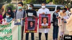 People with photos of activists, who became victims of enforced disappearances, are seen at a rally in Dhaka, on International Human Rights Day, Dec. 10, 2021. (Tazul Islam/VOA)