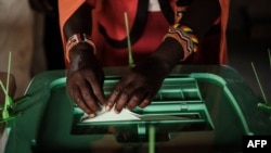 FILE: A Maasai woman casts her vote during Kenya's general election at the Masurura primary school polling station in Masurura. Kenya's female candidates made a historic showing in this August 9 election. 