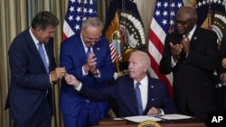 Predsjednik SAD Joe Biden potpisuje zakon o klimatskim promjenama i zdravstvenoj zaštiti u prisustvu demokratskih senatora. (Foto: AP/Susan Walsh)
