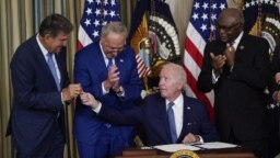 Predsjednik SAD Joe Biden potpisuje zakon o klimatskim promjenama i zdravstvenoj zaštiti u prisustvu demokratskih senatora. (Foto: AP/Susan Walsh)