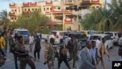 FILE: Security forces and others walk in front of the damaged Hayat Hotel in the capital Mogadishu, Somalia, Aug. 21, 2022. 