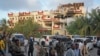 FILE - Security forces and others walk in front of the damaged Hayat Hotel in the capital Mogadishu, Somalia, Aug. 21, 2022. 