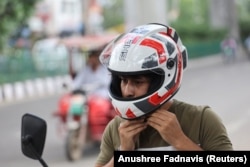 Seorang karyawan Shellios Technolabs, yang memproduksi helm sepeda motor yang dilengkapi dengan filter dan kipas di bagian belakang helm, di kawasan industri, di New Delhi, India, 23 Agustus. 2022. (Foto: REUTERS/Anushree Fadnavis)