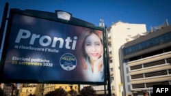 FILE - Pedestrians walk past an election poster of Giorgia Meloni, far-right leader of the Fratelli D'Italia 'Brothers of Italy' party on display in Rome on Aug. 4, 2022. 