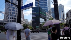 资料照片：2022年8月3日，上海街头的大型电子显示屏显示股票市场的动态。（路透社照片）