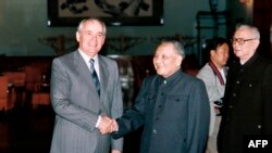 资料照：中共前领导人的邓小平在北京与到访的苏联前领导人戈尔巴乔夫握手。（1989年5月16日）