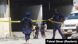 Des agents de sécurité somaliens établissent un cordon de sécurité dans une partie de l'hôtel Hayat, théâtre d'une attaque de militants du groupe al Shabaab lié à Al-Qaïda, à Mogadiscio, en Somalie, le 20 août 2022. 