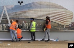 Workers work outside Al Janoub Stadium, one of the 2022 World Cup stadiums, in Doha, Qatar, Monday, Dec. 16, 2019. (AP Photo/Hassan Ammar)