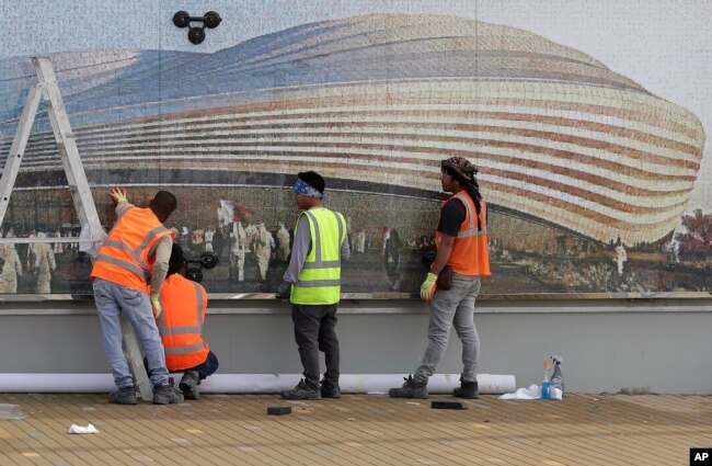 Workers work outside Al Janoub Stadium, one of the 2022 World Cup stadiums, in Doha, Qatar, Monday, Dec. 16, 2019. (AP Photo/Hassan Ammar)