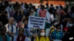 Seorang demonstran menunjukkan poster yang memprotes penundaan hukuman bagi sejumlah pria yang dipidana melakukan pemerkosaan massal terhadap seorang perempuan muslim, di New Delhi, India, Sabtu, 27 Agustus 2022. (Foto: Altaf Qadri/AP Photo)