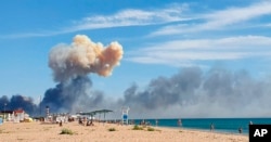 Rising smoke can be seen from the beach at Saky after explosions were heard from the direction of a Russian military airbase near Novofedorivka, Crimea, Aug. 9, 2022.