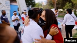 Un activista abraza a Rosa Hernández, madre de Diana Rocío Ramírez Hernández, desaparecida en 1992, durante una marcha para conmemorar el Día Internacional de las Víctimas de Desapariciones Forzadas, en Ciudad Juárez, México, el 30 de agosto de 2022. 