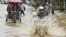 Commuters travel through a flooded street after heavy rains at Guwahati, in the northeastern Indian state of Assam, June 26, 2012. 