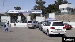 Cars with travelers line up at the entrance gate of Hamid Karzai International Airport, in Kabul, Afghanistan, Aug. 15, 2021.