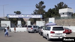 Cars with travelers line up at the entrance gate of Hamid Karzai International Airport, in Kabul, Afghanistan, Aug. 15, 2021.