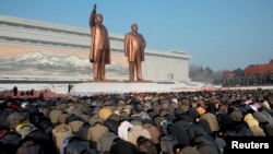 지난 2012년 12월 북한 김정일 사망 1주기를 맞아 평양 만수대 김일성, 김정일 동상을 찾은 주민들이 묵념을 하고 있다.