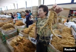 FILE - A ginseng dealer holds a 6-year-old root at a market in Geumsan, South Korea, about 200 km (124 miles) south of Seoul, Sept. 2, 2009.