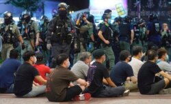 La policía de Hong Kong custodia a manifestantes arrestados durante las protestas del 1 de julio de 2020.