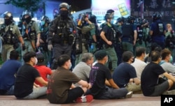 La policía de Hong Kong custodia a manifestantes arrestados durante las protestas del 1 de julio de 2020.