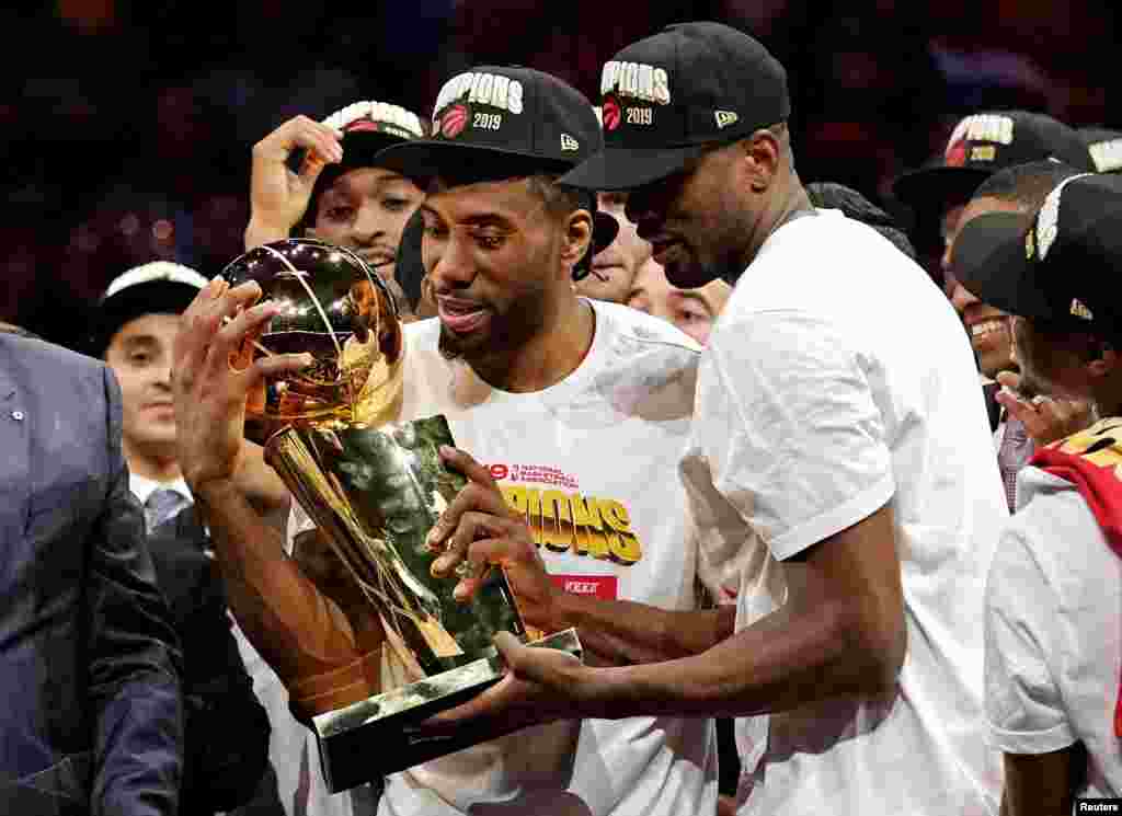 Toronto Raptors forward Kawhi Leonard (2) and Toronto Raptors center Serge Ibaka (9) celebrate with the Larry O'Brien Trophy after the Golden State Warriors in game six of the 2019 NBA Finals, Oakland, CA., June 13, 2019. (Kyle Terada-USA Today Sports))