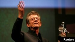 FILE - British actor John Hurt holds the Gold Giraldillo Award as a tribute to his career during the Sevilla European film festival in the Andalusian capital of Seville, Nov. 7, 2009.