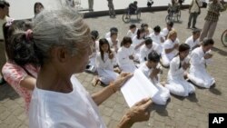 FILE - Rape victims who never received hearings for allegations pray in front of Royal Palace, Phnom Penh, Cambodia.