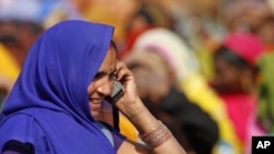 An Indian woman talks on her mobile phone at an election rally in Faizabad, India, Feb. 2, 2012.