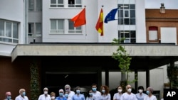 Health services staff members stand outside at Navarra Hospital in a two minute silence in tribute for members of staff who died of coronovirus, in Pamplona, northern Spain, May 14, 2020.