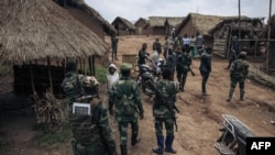 Patriotic Front for Peace/People's Army militiamen, one of the largest armed groups in North Kivu, led by self-proclaimed general Kabido, walk around their headquarters in Mbwavinwa, Lubero territory, eastern Democratic Republic of Congo on May 5, 2024. (ALEXIS HUGUET / AFP)
