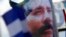 ARCHIVO - Una pancarta adornada con una imagen del presidente de Nicaragua, Daniel Ortega, es agitada por un partidario en Managua, Nicaragua, el 30 de abril de 2018.